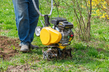 Cultivator for tillage in the garden,motor cultivator. Man Farmer plows the land with a cultivator.