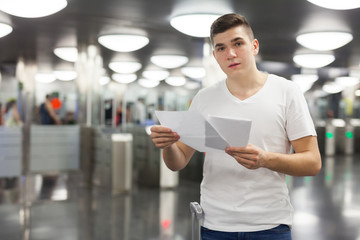 Man holding papers on subway station