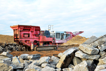 Mobile Stone crusher machine by the construction site or mining quarry for crushing old concrete slabs into gravel and subsequent cement production. Jaw crusher with conveyor belt