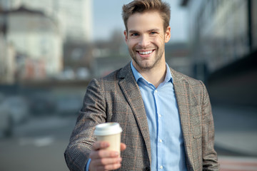 Young handsome man in a jacket smiling positively