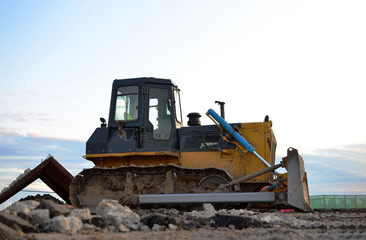 Track-type bulldozer, earth-moving equipment. Land clearing, grading, pool excavation, utility trenching, utility trenching and foundation digging during of large construction jobs.