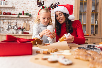 Woman and a girl using icing squeeze bottles