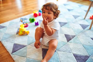 Beautiful toddler child girl playing with toys on the carpet