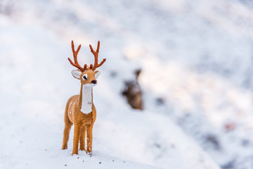 Toy Deer Doll in a Snowy Winter Forest