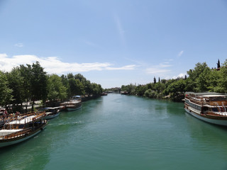 Fototapeta premium One of the tourist cities of Turkey. View from the bridge to the river and the ships that stand at the berths