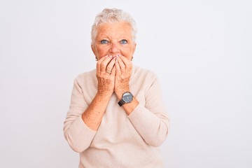 Senior grey-haired woman wearing turtleneck sweater standing over isolated white background laughing and embarrassed giggle covering mouth with hands, gossip and scandal concept