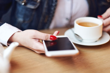 Business woman hands using smart phone and cup of coffee.