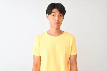 Obraz premium Chinese man wearing yellow casual t-shirt standing over isolated white background depressed and worry for distress, crying angry and afraid. Sad expression.