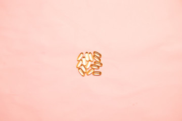 Top view of assorted multi-colored medical capsules, tablets on a pink background. Dietary supplements and diet concept