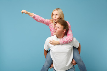 Young fun couple two friends guy girl in white pink empty blank design t-shirts posing isolated on...