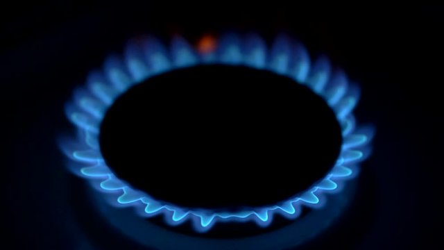 Flame of gas on kitchen stove. Slow motion shot of gas stove ignites