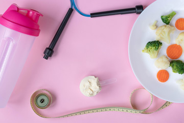 Healthy lifestyle - jump rope, protein powder, shaker, vegetables