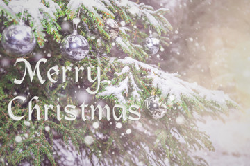 Merry Christmas! Happy  New Year! Blurred background of beautiful Christmas tree, snowfall and bright silver lights, toys, illumination. Bokeh. Happy New Year. Wallpaper. Greeting Postcard.