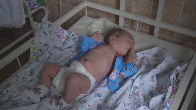 Little caucasian boy beautiful baby infant lies in the hospital before discharge. Maternity hospital, close-up