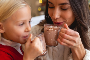 Child and her mother enjoying hot chocolate