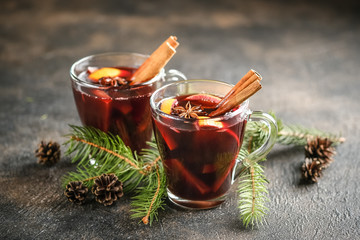 Mulled wine in glasses with apples, orange, cinnamon and star anise. Hot Christmas drink on a dark...