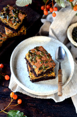 Chocolate pumpkin brownie on a plate on a dark wooden background, still life