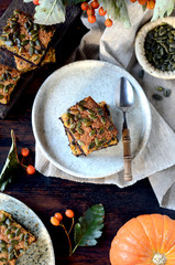 Chocolate pumpkin brownie on a plate on a dark wooden background, still life