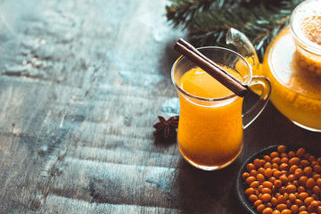 Autumn or winter sea buckthorn drink. Sea Buckthorn tea, selective focus. Still life, food and drink, seasonal and holidays concept. Autumn hot beverage in a glass