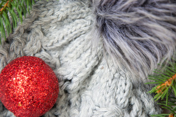 Close-up of gray winter hat with pompom and Christmas toys, pine tree branches, warm  xmas concept
