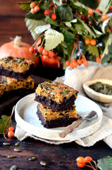 Chocolate pumpkin brownie on a plate on a dark wooden background, still life