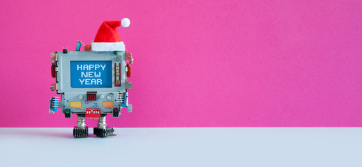 Santa Claus computer wishes Happy New Year. Funny festive greeting card retro device, made of mixed electronic parts, dressed red Santa hat. Blue display media interface with congratulations.
