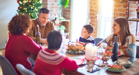 Beautiful family smiling happy and confident. Eating roasted turkey celebrating christmas at home
