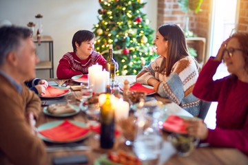 Beautiful family smiling happy and confident. Eating roasted turkey celebrating christmas at home