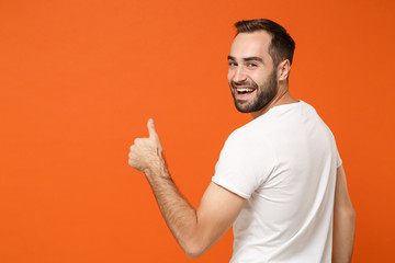 Back rear view of smiling young man in casual white t-shirt posing isolated on orange wall...
