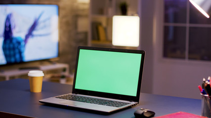 Desktop computer with green screen on home office.