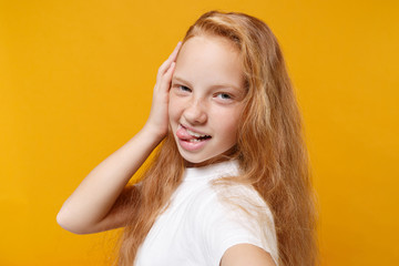 Fototapeta premium Close up of funny little ginger kid girl 12-13 years old in white t-shirt isolated on yellow background in studio. Childhood lifestyle concept. Mock up copy space. Doing selfie shot on mobile phone.