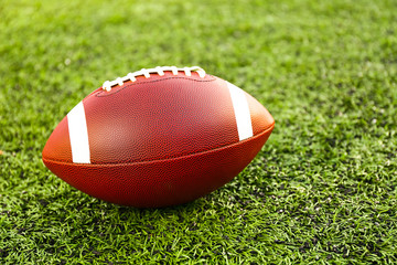 Rugby ball on green field outdoors