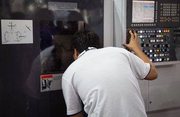 Industrial technician input data to operate cnc machine