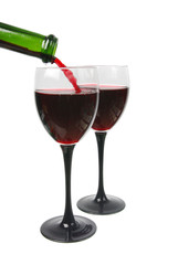 Red wine is poured from a bottle into a glass. White background