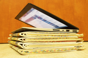 Stack of Newspapers and Laptop. Personal Computer and Business Magazines. Concept for News - Different Sources of Information 