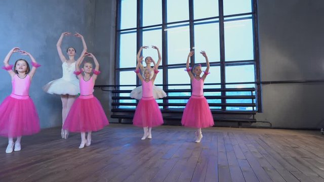 Little girls dance ballet. Children in ballet class. Little ballerinas and teacher.