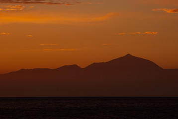 Sunset over the volcano Teide, Tenerife, seen from Puerto de Mogán, Gran Canaria