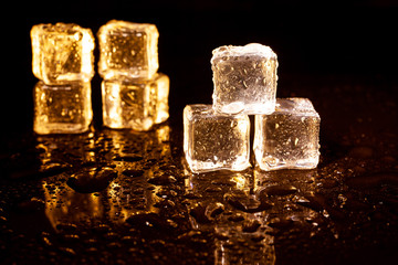 Golden ice cubes on black background.