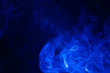 Fototapeta na wymiar Blue smoke on black background.