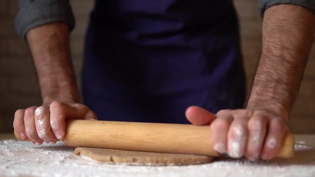 Male hands&nbsp;rolling out ginderbread dough cooking honey-cake at home