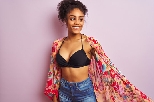 Young beautiful african american woman on vacation standing wearing bikini and colorful caftan