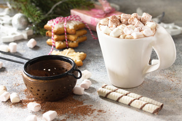 Christmas dessert or breakfast. A cup of hot cocoa with marshmallows and Christmas baking on a stone countertop.