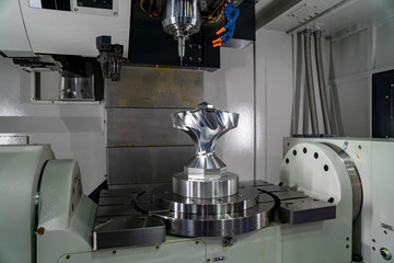 The 5-axis CNC milling machine  cutting the sample of aluminium  parts by solid ball endmill tools. The automotive parts manufacturing process by 5-axis machining center.