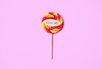 Pink round candy on a stick with the inscription 