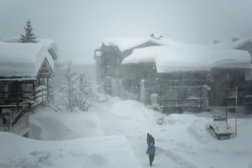Heavy snow storm at Val d'Isere, Savoie of France. Buildings covered with snow during hard winter conditions on January at French Alps.