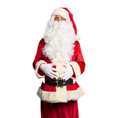 Middle age handsome man wearing Santa Claus costume and beard standing smiling and laughing hard out loud because funny crazy joke with hands on body.