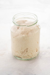 Natural leaven for bread in a glass jar. A living product. The concept of a healthy diet. Sourdough starter