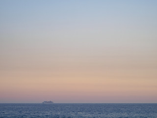 Passenger liner away on the horizon in the ocean.