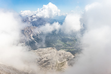 Krajobraz Dolomitów wynurzający się z chmur. Widok ze szczytu. Wędrówka w chmurach.