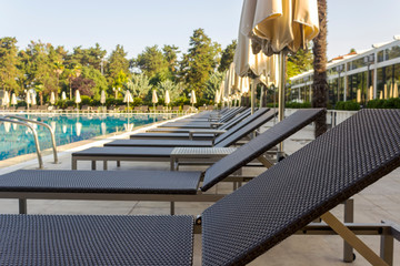Sun beds by the pool in the open air. Pool at the spa resort.